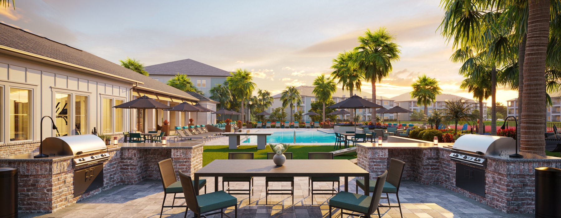 table chairs patio BBQ grills sunset hues palm trees pool and sundeck in background clubhouse