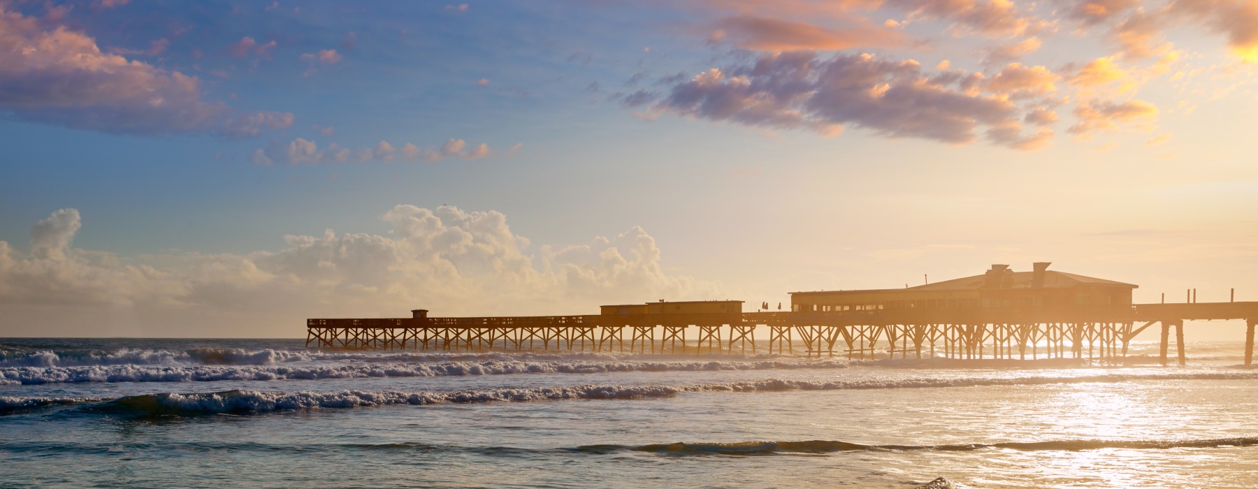 daytona beach shoreline sunset ocean water sand pier clouds