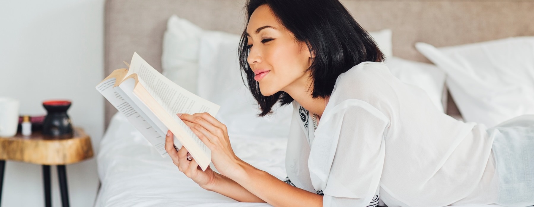 a person lying in bed reading a book